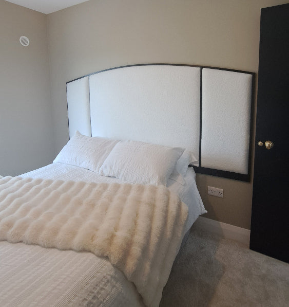 white upholstered headboard in bedroom with white bedding
